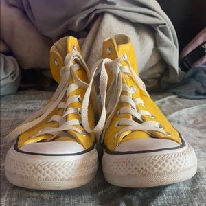 Yellow high top converse.